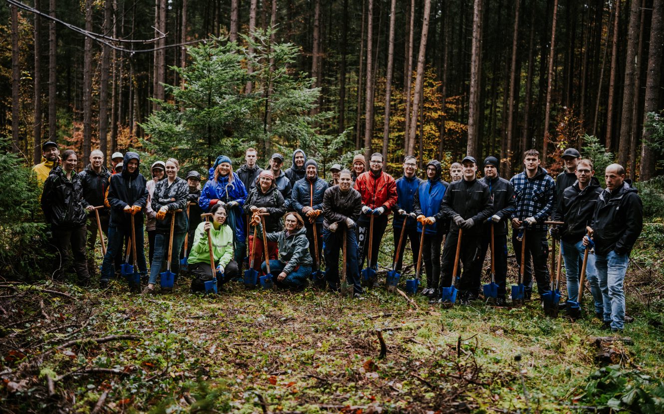 Gruppenbild von 25 Mitarbeitern der MTU Aero Engines mit Deutim und Försterin an ihrem Waldtag in Dietramszell